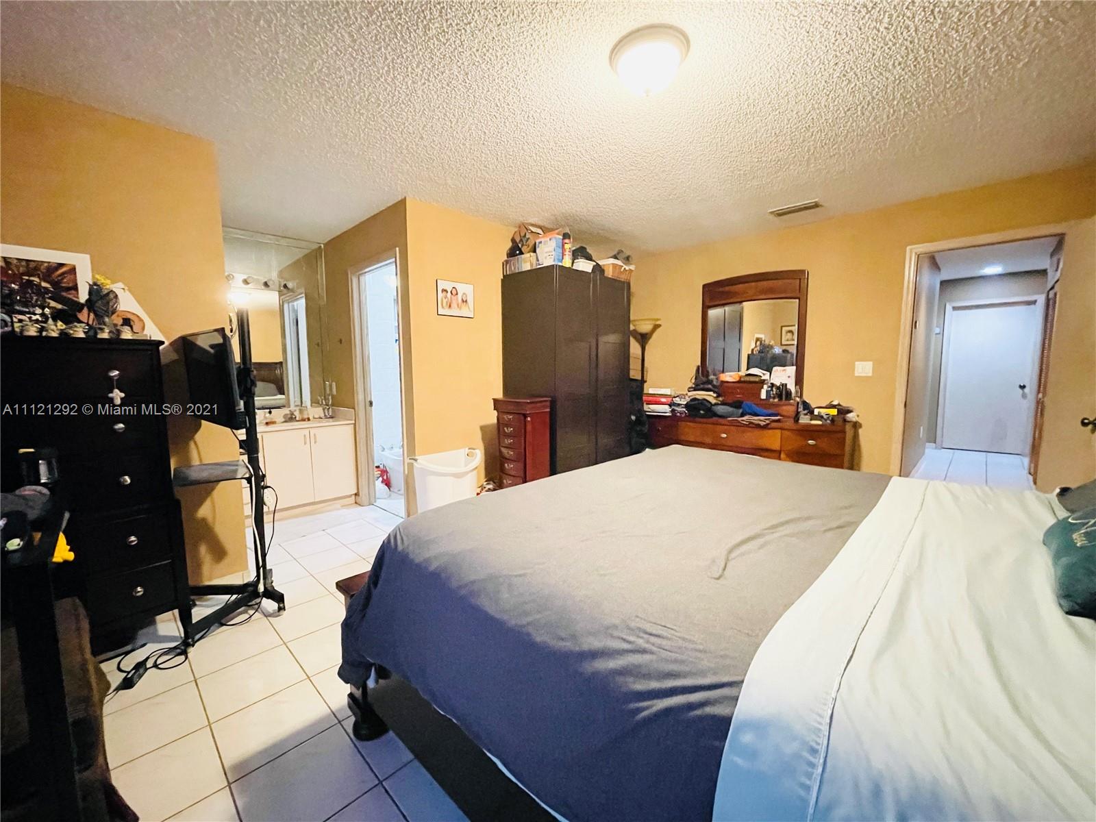 1245 Southwest 143rd Place Miami, FL 33184 - Photo 16 of 23 a bed room with a bed and a large mirror