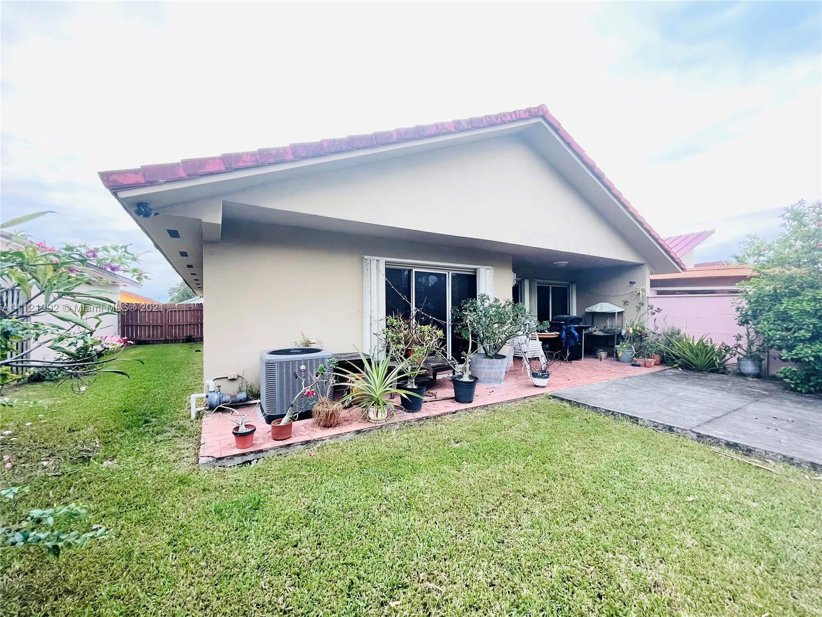 1245 Southwest 143rd Place Miami, FL 33184 - Photo 22 of 23 a front view of a house with porch and garden