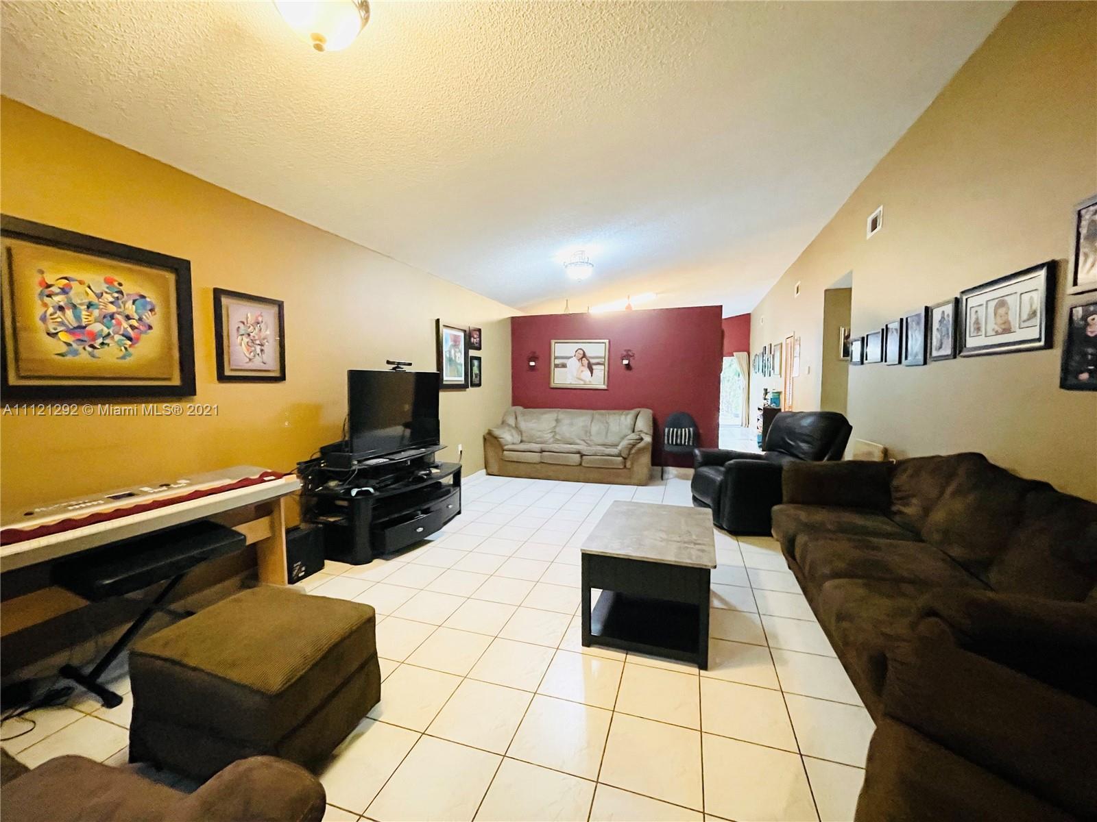 1245 Southwest 143rd Place Miami, FL 33184 - Photo 4 of 23 a living room with furniture and a flat screen tv