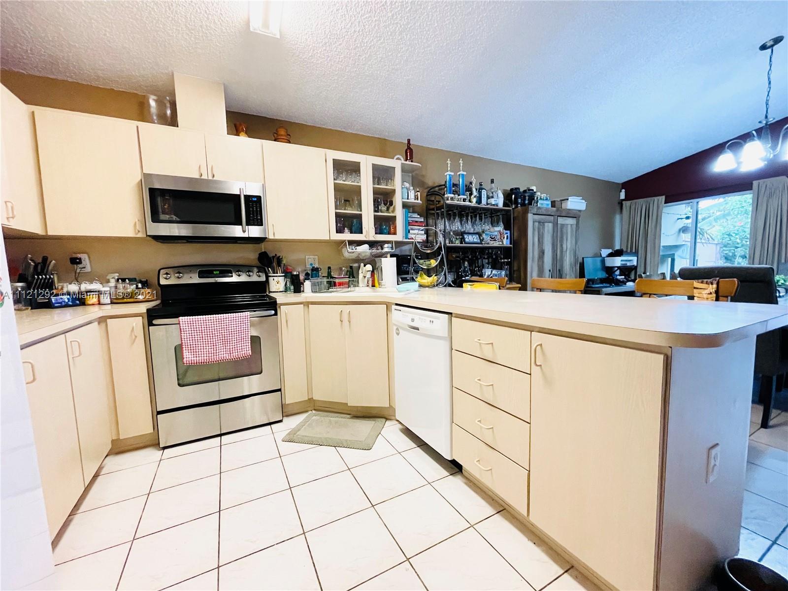 1245 Southwest 143rd Place Miami, FL 33184 - Photo 6 of 23 a kitchen with stainless steel appliances a sink and a stove top oven