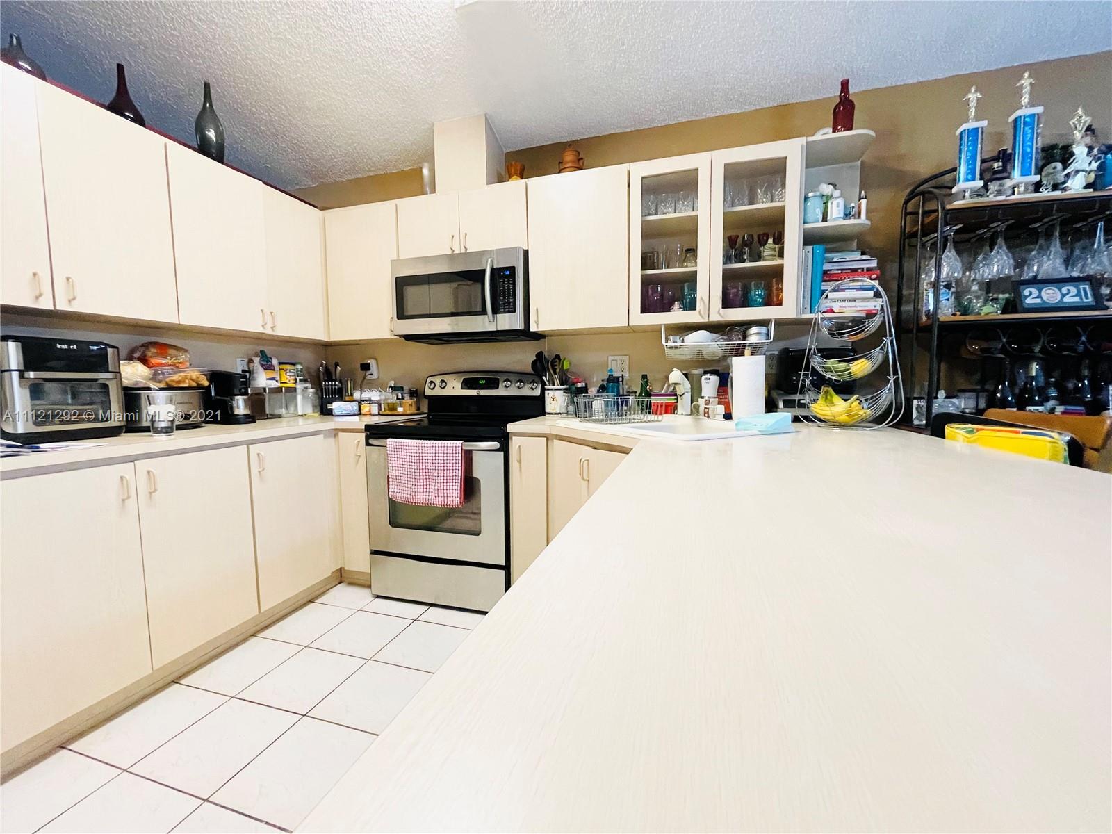 1245 Southwest 143rd Place Miami, FL 33184 - Photo 7 of 23 a kitchen with stainless steel appliances a stove a sink and cabinets