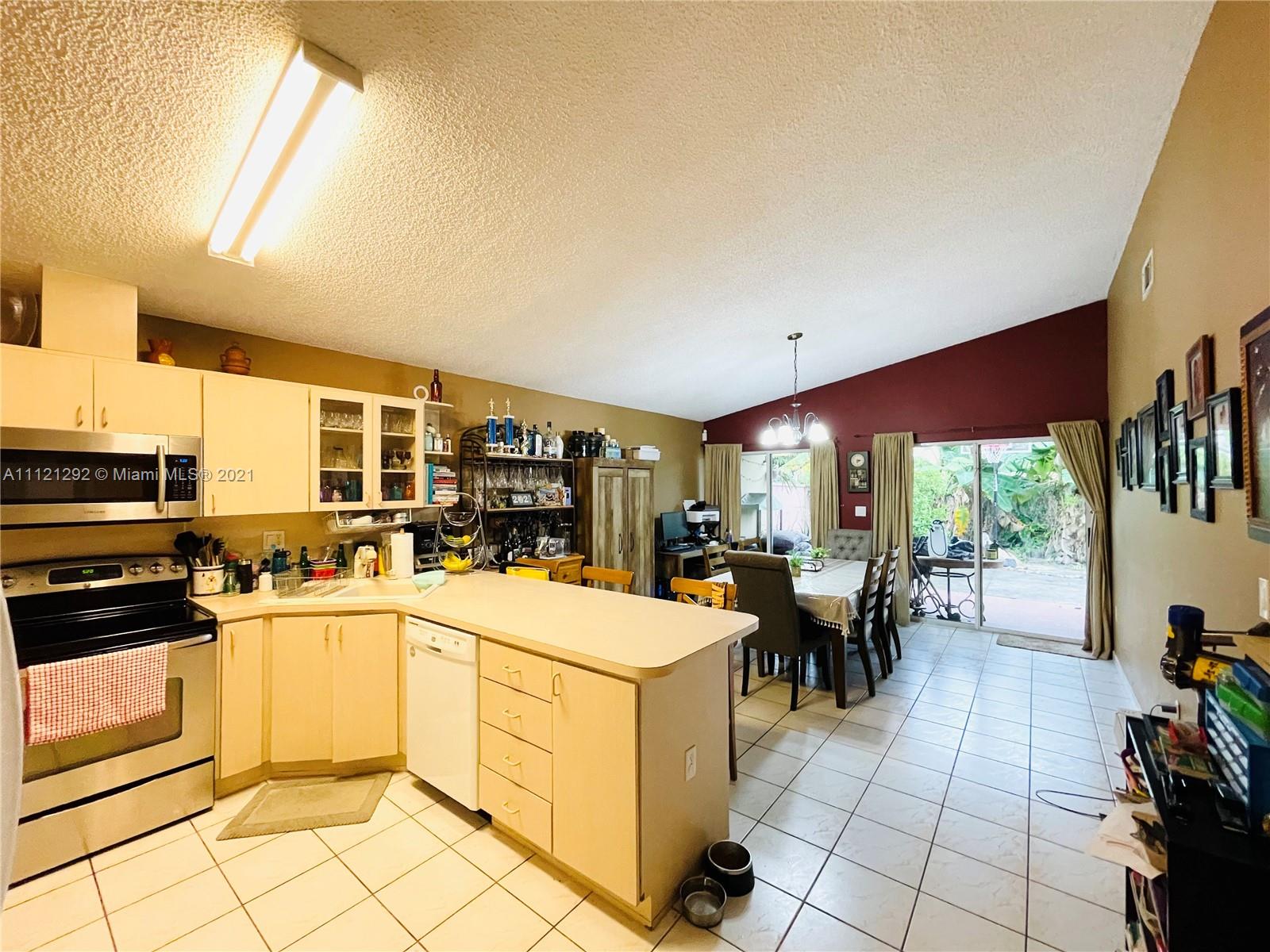 1245 Southwest 143rd Place Miami, FL 33184 - Photo 8 of 23 a kitchen with a table chairs stove and cabinets