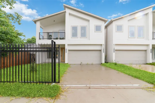 a front view of a house with a garden and plants