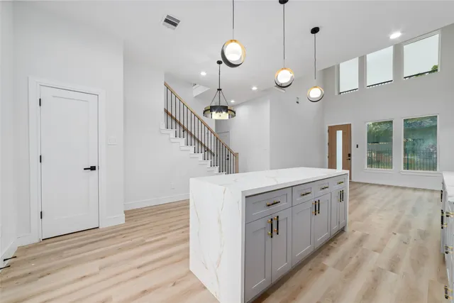 a kitchen with stainless steel appliances kitchen island a large island in a room