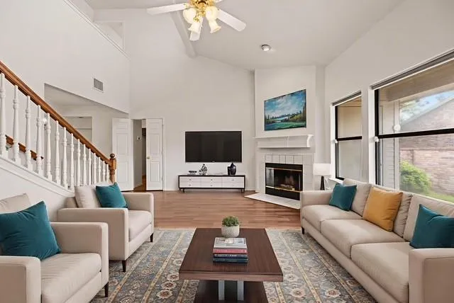 a living room with furniture a flat screen tv and a fireplace