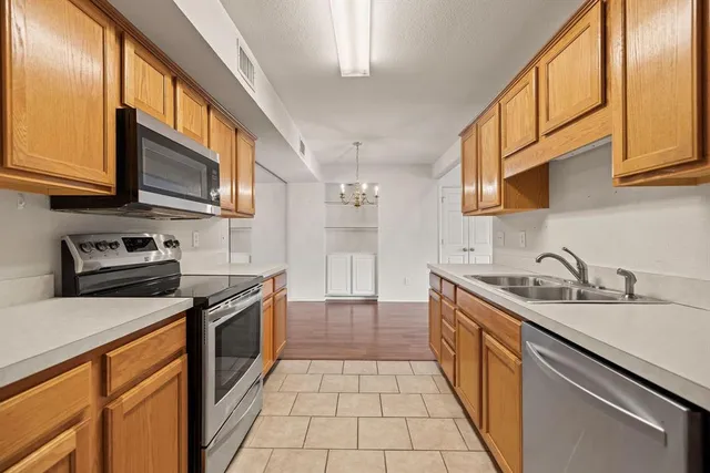 a kitchen with stainless steel appliances granite countertop a sink and cabinets with wooden floor