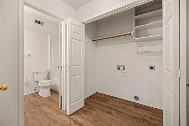 an empty room with a chandelier fan and windows