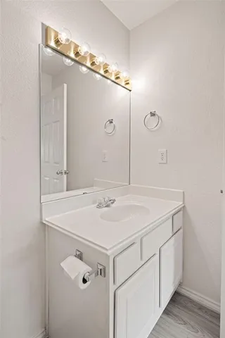 a view of a wooden house with a small yard and large trees