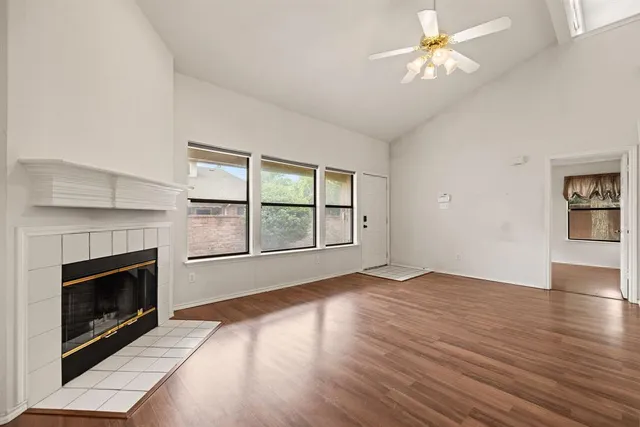 a view of a livingroom with a fireplace a chandelier and wooden floor