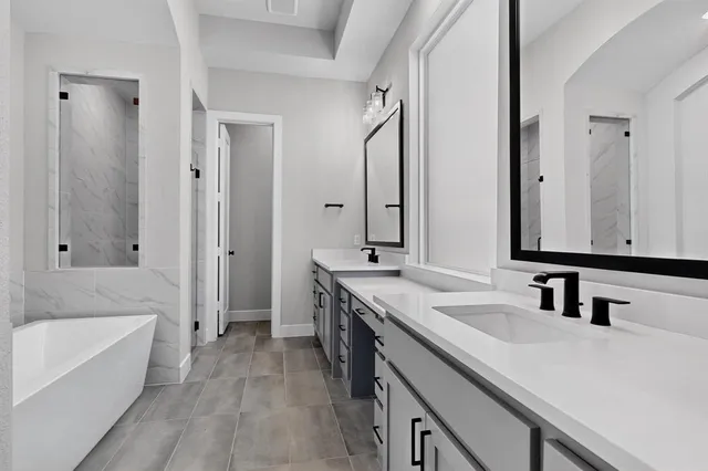 a bathroom with a tub sink and mirror