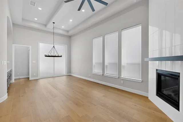 an empty room with windows and fireplace