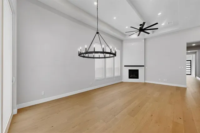 a view of a room with wooden floor ceiling fan and window