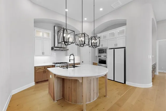 a kitchen with stainless steel appliances granite countertop a sink a refrigerator and a stove