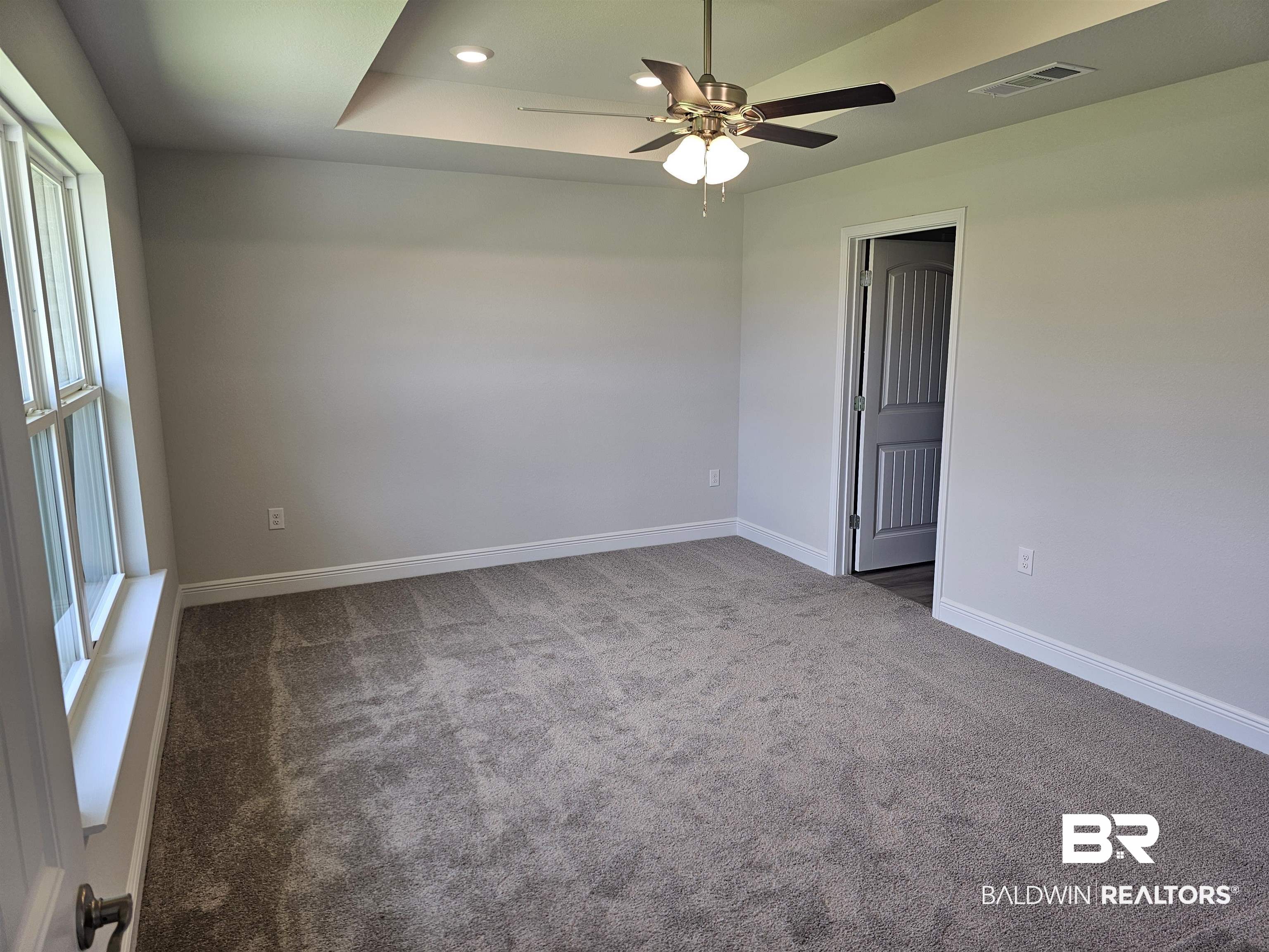1412 Plymouth Drive Foley, AL 36535 - Photo 9 of 10 Carpeted spare room featuring plenty of natural light, a tray ceiling, and ceiling fan