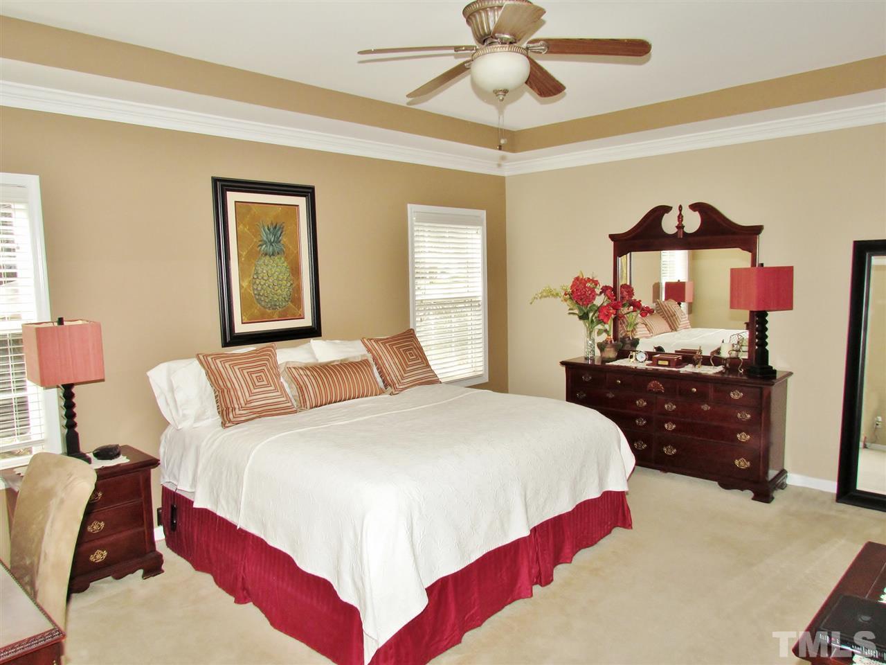 101 Mickleson Ridge Drive Raleigh, NC 27603 - Photo 10 of 25 a bedroom with a bed and a chandelier