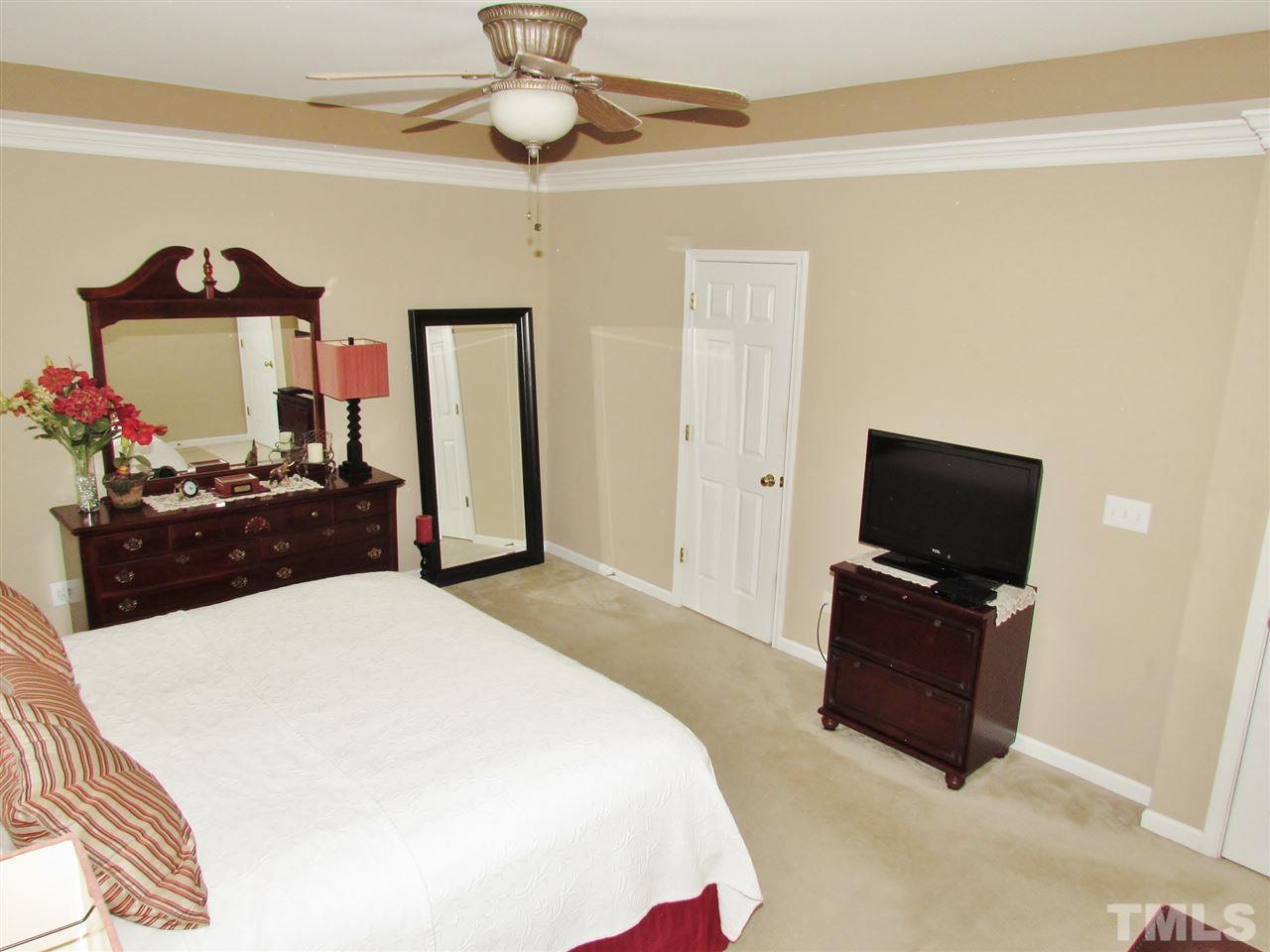 101 Mickleson Ridge Drive Raleigh, NC 27603 - Photo 11 of 25 a bedroom with a bed and a flat screen tv