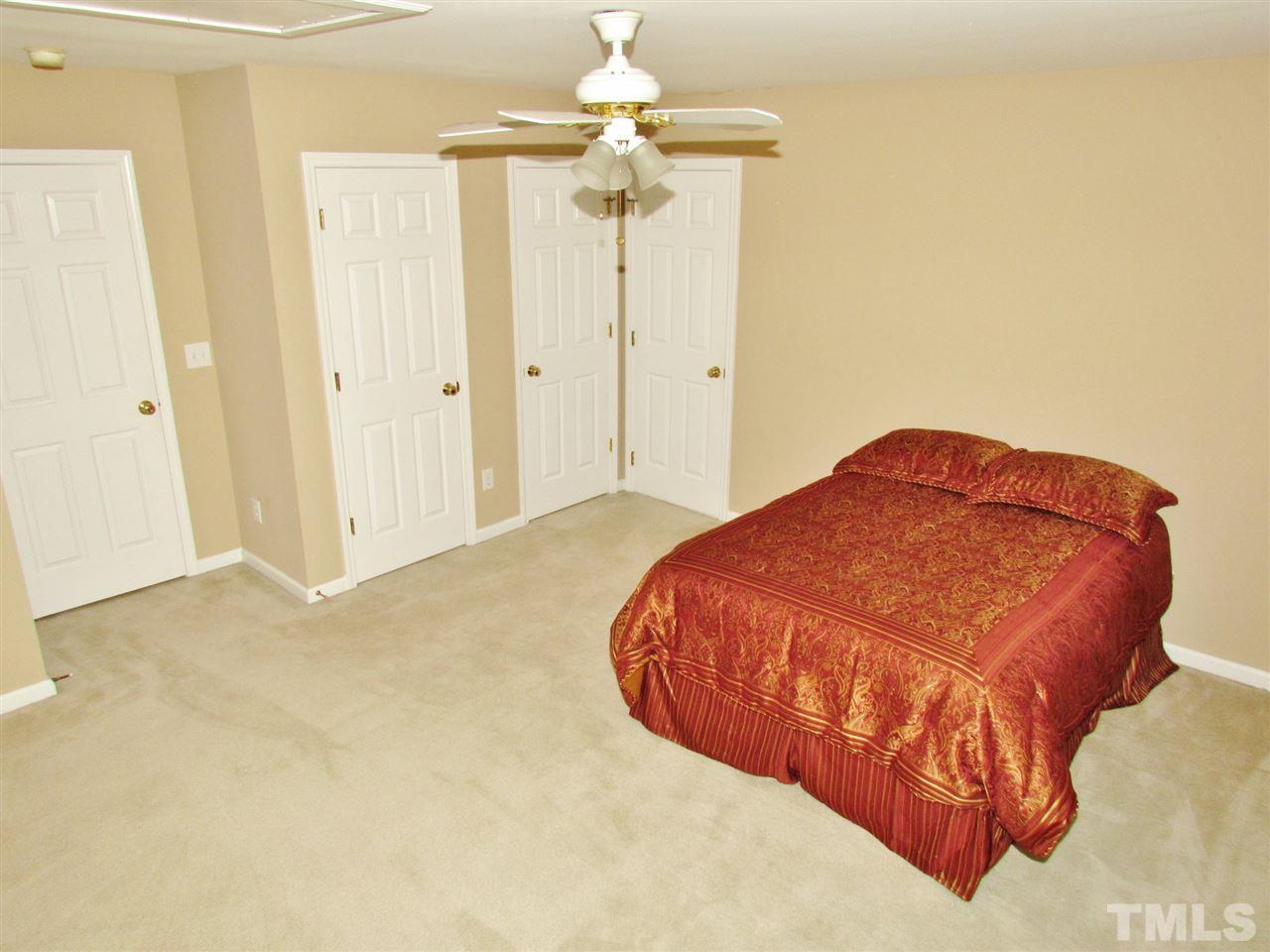 101 Mickleson Ridge Drive Raleigh, NC 27603 - Photo 15 of 25 a bedroom with a bed and a chandelier