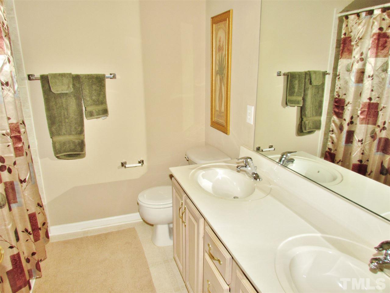 101 Mickleson Ridge Drive Raleigh, NC 27603 - Photo 16 of 25 a spacious bathroom with a sink a toilet and shower curtain