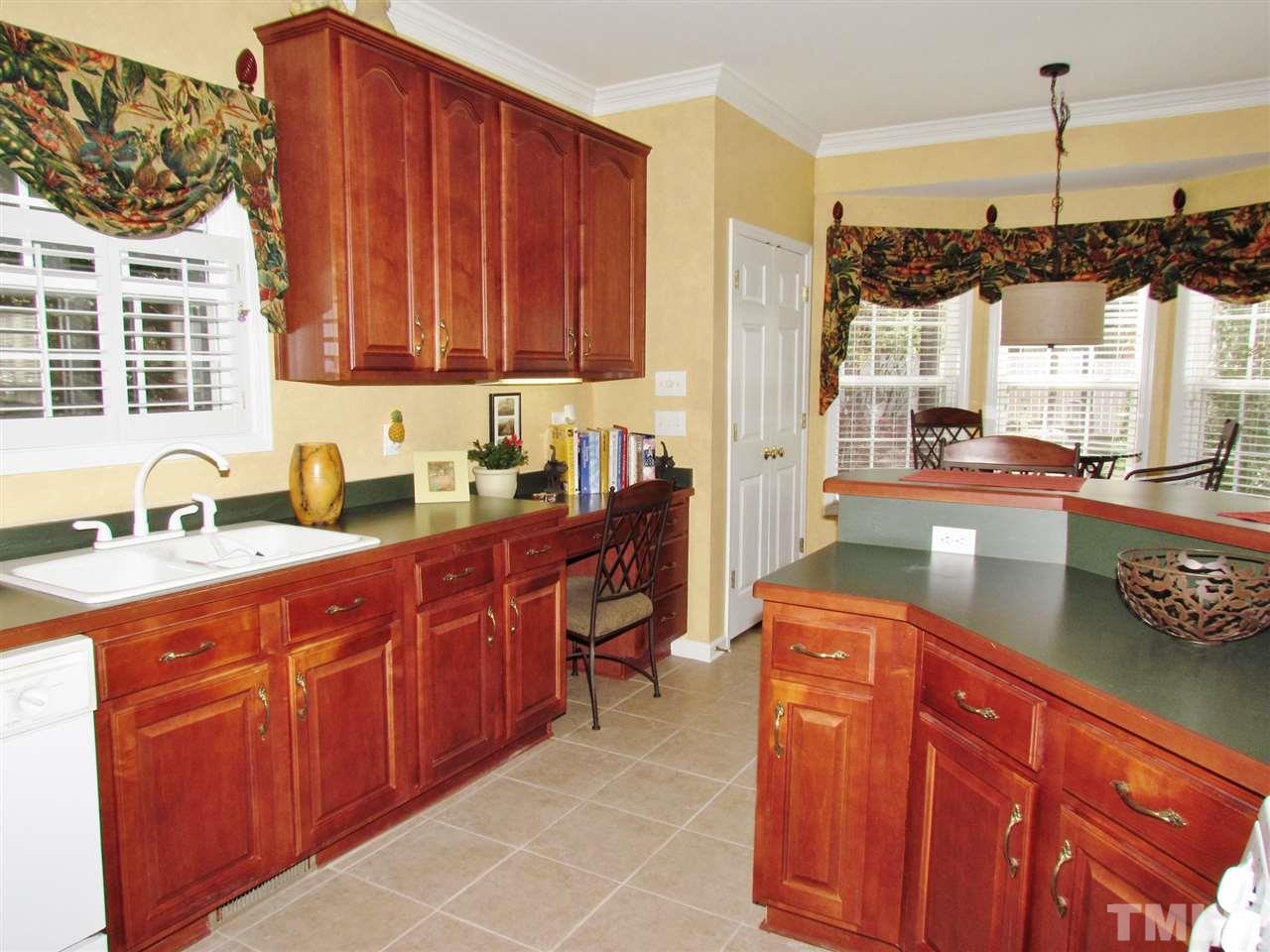 101 Mickleson Ridge Drive Raleigh, NC 27603 - Photo 7 of 25 a kitchen with stainless steel appliances granite countertop wooden cabinets a sink and a stove