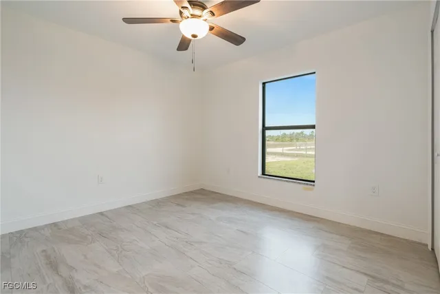 an empty room with a window and a fan