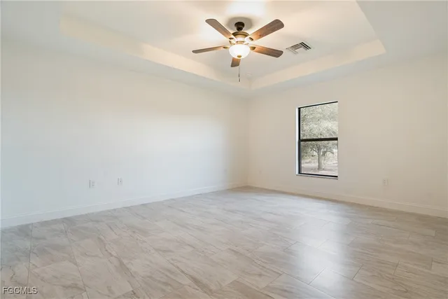 an empty room with a window and a fan