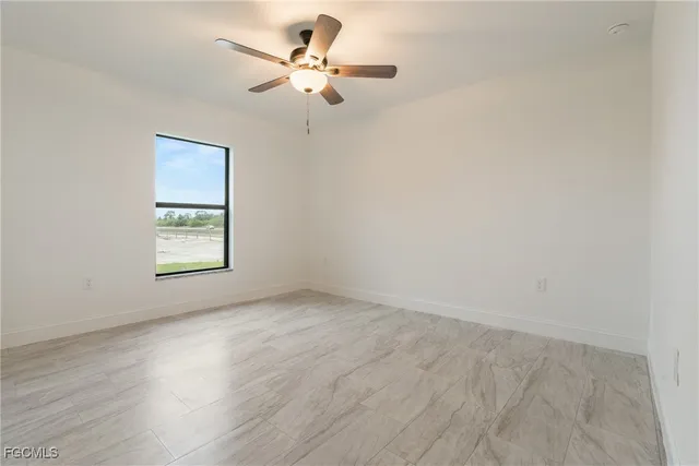 an empty room with a window and a fan