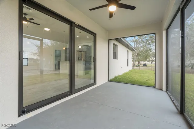 a view of a hallway with a livingroom to ceiling window and chandelier