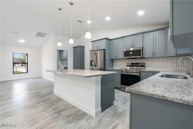 a kitchen with stainless steel appliances granite countertop a sink stove and refrigerator