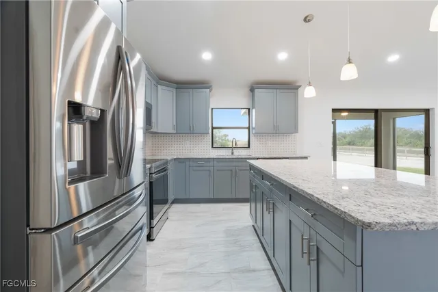 a kitchen with stainless steel appliances granite countertop a refrigerator and a sink