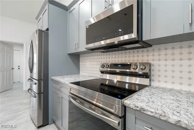 a kitchen with stainless steel appliances granite countertop a stove a microwave and a refrigerator