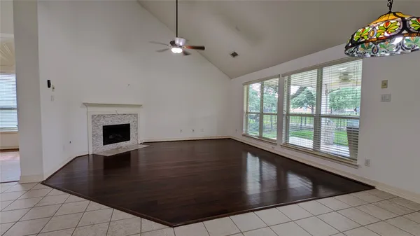 an empty room with windows and ceiling fan