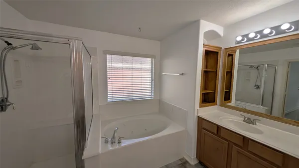a bathroom with a tub sink and mirror