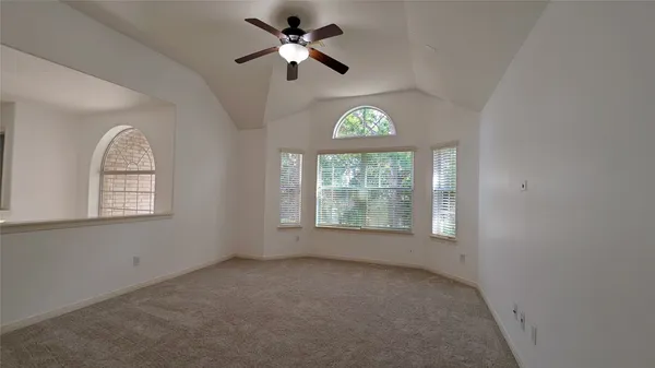 an empty room with a window and a fan