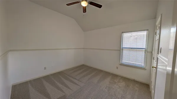 an empty room with a window and a ceiling fan