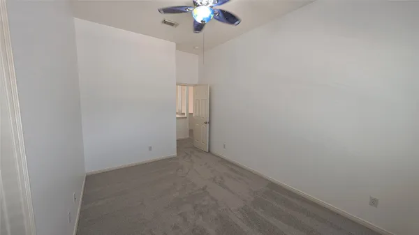 an empty room with a chandelier fan and closet