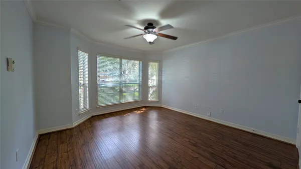 a view of wooden floor and a chandelier fan in a room