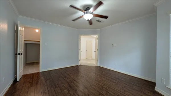 a view of an empty room with wooden floor