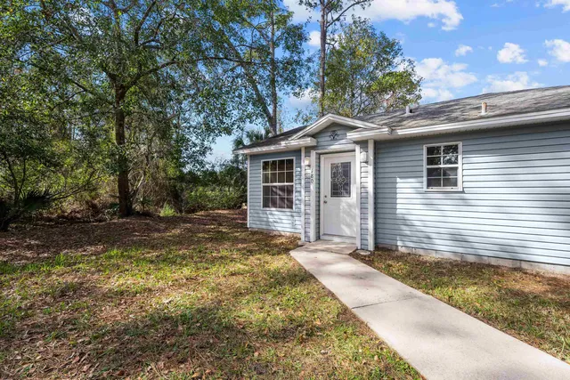 a front view of a house with a garden and yard