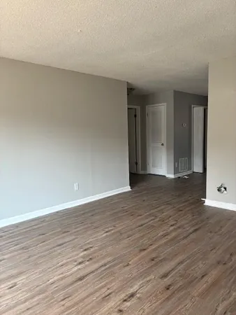 a view of an empty room and wooden floor