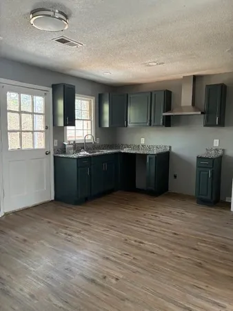 a view of kitchen with stainless steel appliances granite countertop a sink and cabinets with wooden floor