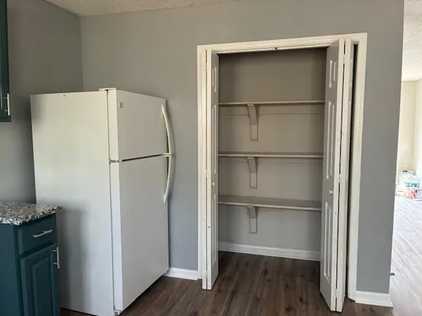 a white refrigerator freezer and a wooden floor