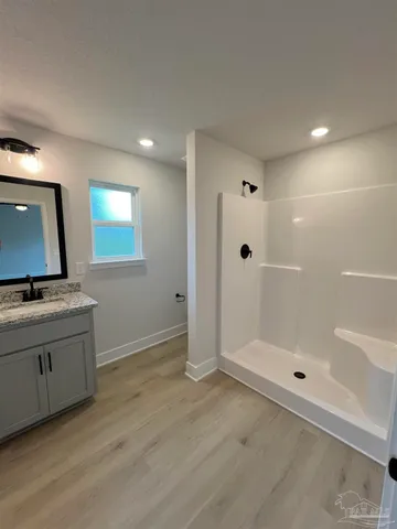 a bathroom with a sink a toilet and shower