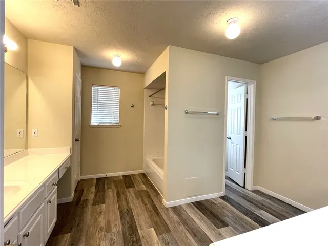 a view of a hallway with wooden floor and a sink