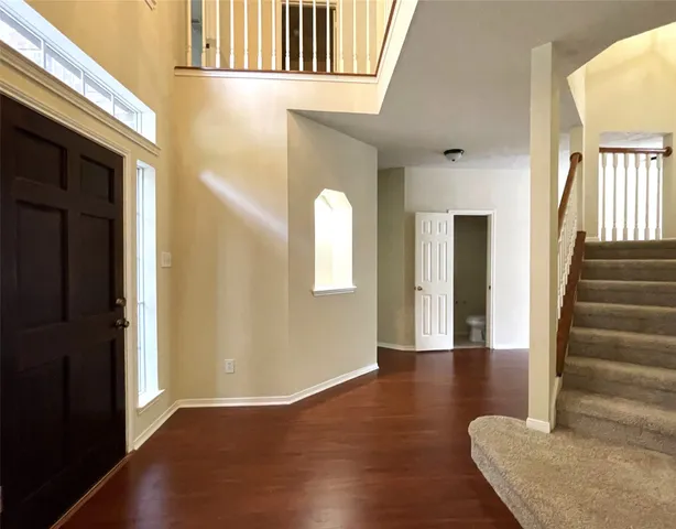 a view of an entryway with wooden floor and door