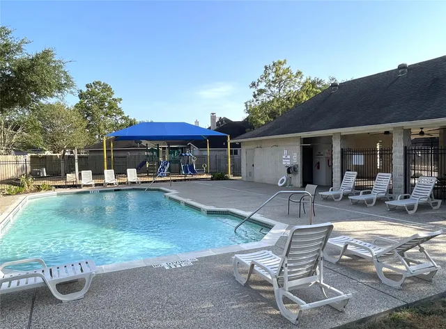 a view of a patio with a table and chairs under an umbrella