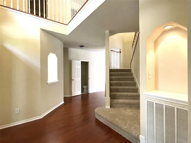 a view of a hallway with wooden floor and entryway