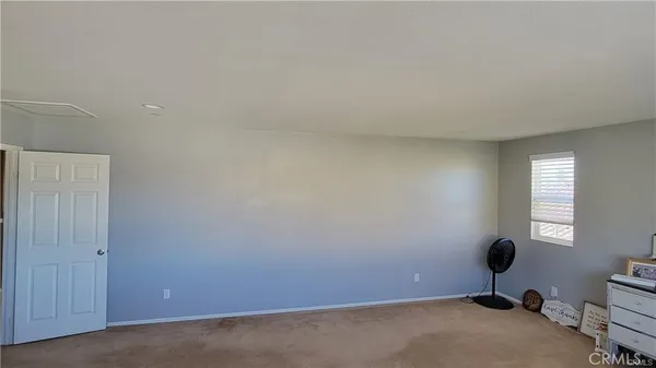 a view of a room with a window and a fan