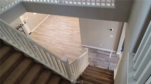 a view of a hallway with wooden floor and staircase