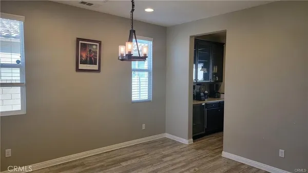 an empty room with wooden floor closet and windows