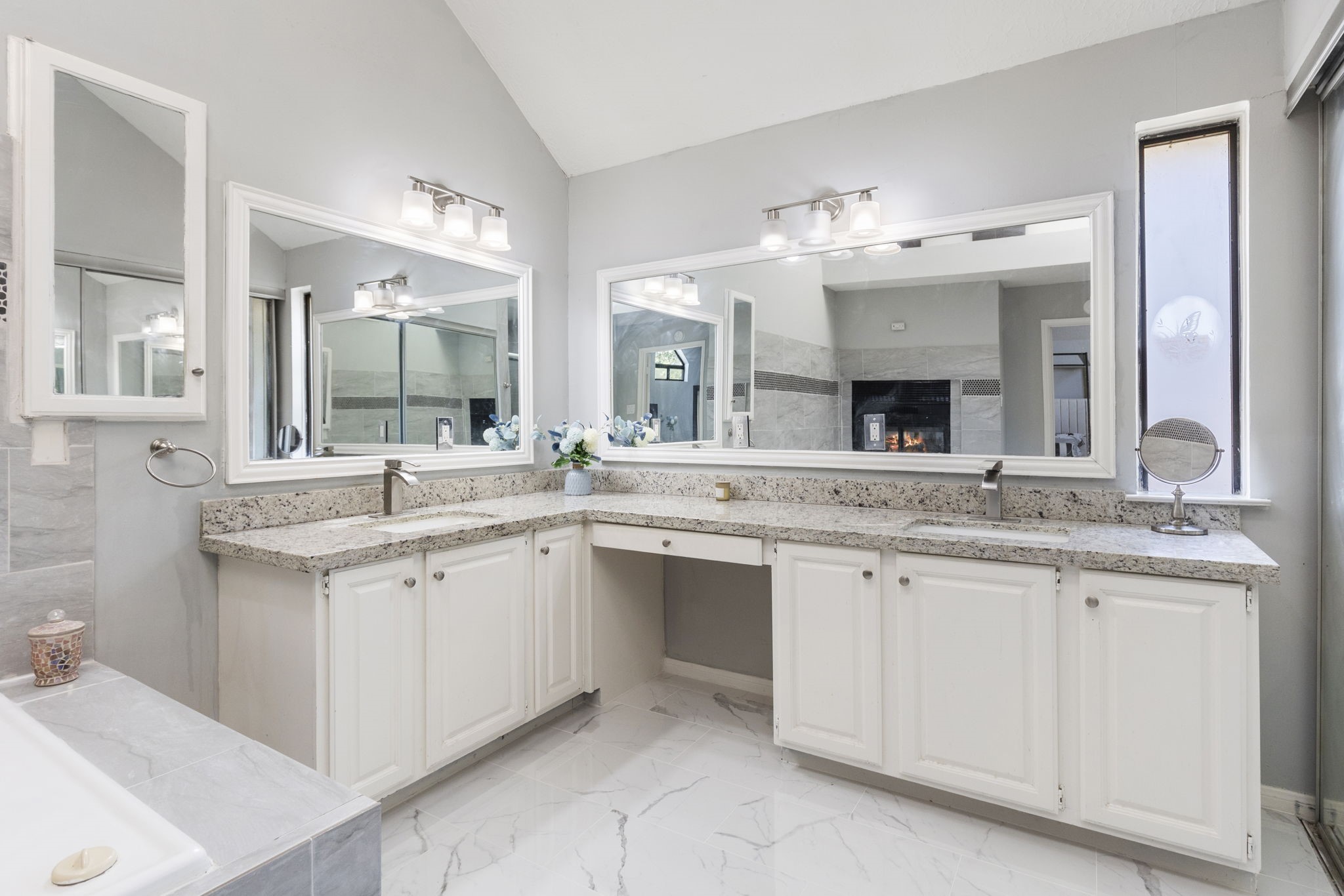 2110 Paso Rello Drive Houston, TX 77077 - Photo 28 of 41 This bathroom features a spacious double vanity with granite countertops and ample storage. It has large mirrors, modern light fixtures, and a bright, airy feel with light-colored walls and flooring.